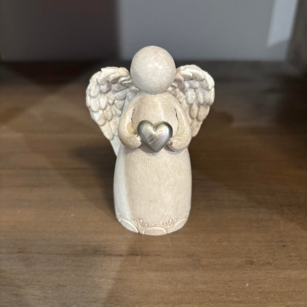 White angel figurine with silver heart